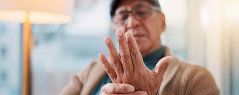 Ein älterer Mann mit schmerzenden Fingergelenken